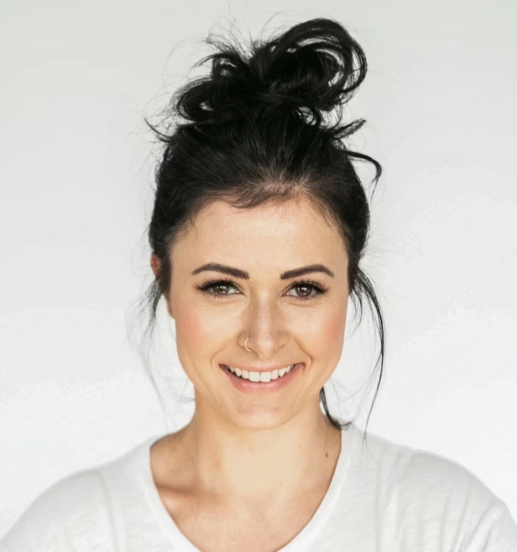 women with dark hair in messy bun smiling